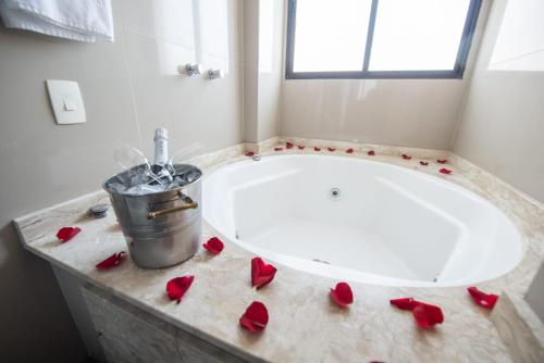 a bathroom with red roses on a bath tub at Olavo Bilac Hotel in Taubaté