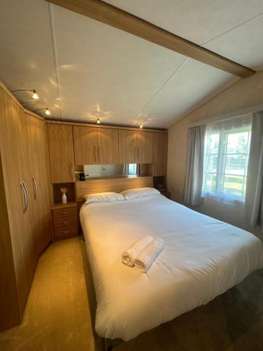 Un dormitorio con una cama grande con una toalla encima. en 56 Main Park Caravan Hire Lillardsedge Holiday Park Jedburgh, en Jedburgh