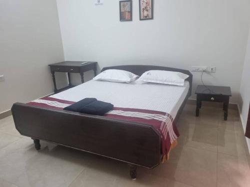 a bedroom with a large bed with two tables at ECR 1 Spacious 3BHK Villa with Swimming pool in Chengalpattu