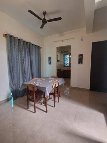 a dining room with a table and a ceiling fan at ECR 1 Spacious 3BHK Villa with Swimming pool in Chengalpattu