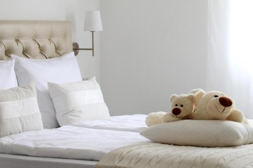 two teddy bears are sitting on a bed at Apartments Villa Mantinela in Malinska