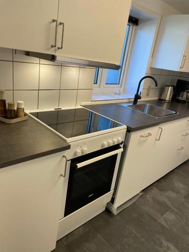 a kitchen with a sink and a stove top oven at Apartment close to the center of Aalborg in Nørresundby