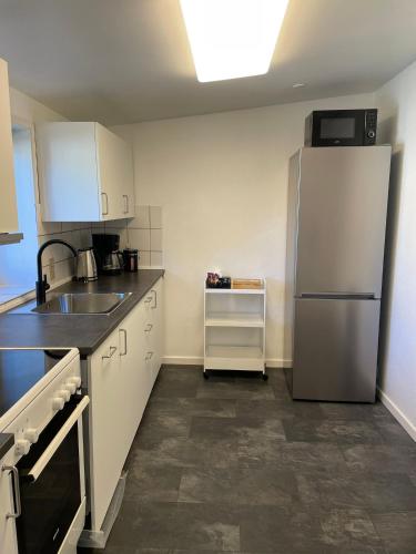 a kitchen with a refrigerator and a sink at Apartment close to the center of Aalborg in Nørresundby