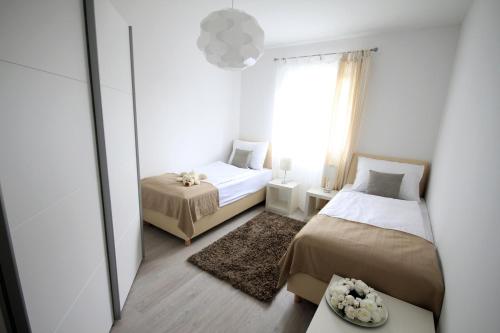 a small bedroom with two beds and a mirror at Apartments Villa Mantinela in Malinska