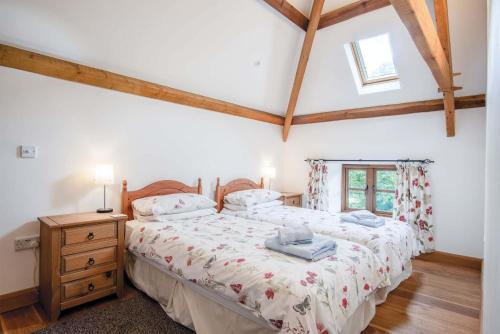 a bedroom with a bed and a dresser and a window at The Stables - 3 Bedroom Cottage - Beavers Hill in Manorbier