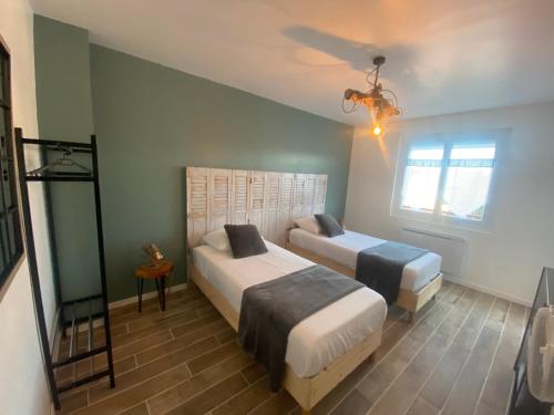 une chambre avec deux lits et un ventilateur de plafond dans l'établissement Maison rénovée avec jardin, à Fos-sur-Mer
