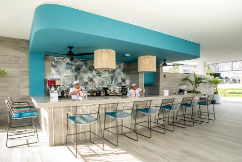 a kitchen with a blue ceiling and a bar with stools at Riu Palace Kukulkan - Adults Only - All Inclusive in Cancún