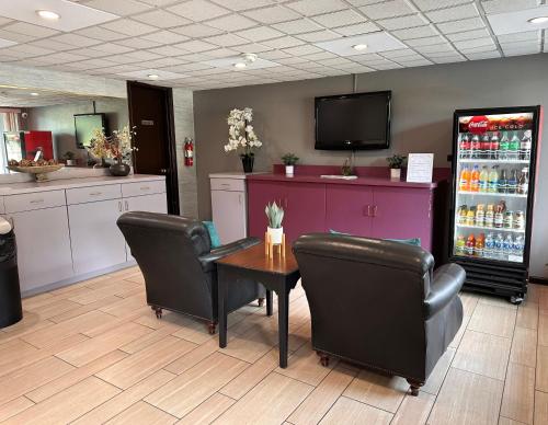 a restaurant with a table and chairs and a refrigerator at Travelers Inn Elizabeth City in Elizabeth City