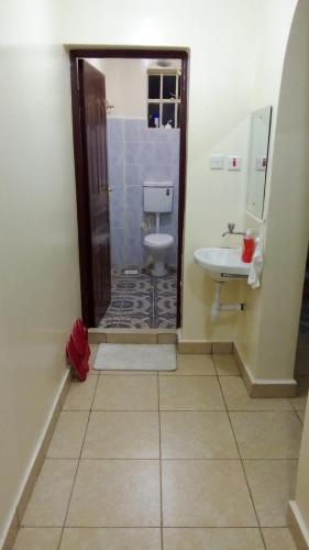 a bathroom with a toilet and a sink at Haven of tranquility in Kiambu