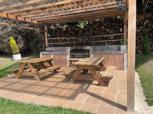 a patio with two picnic tables and a grill at Hermosa Casa Campestre en el Lago Calima in Madroñal