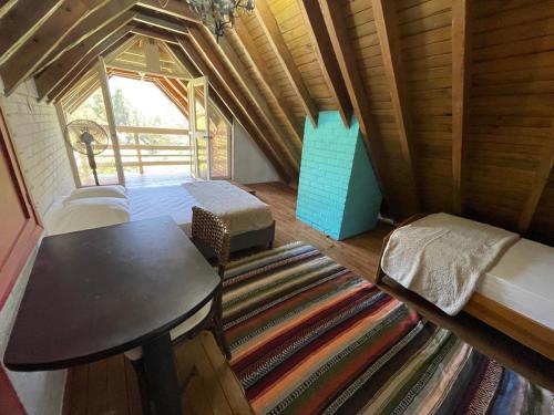 a room with a bed and a table and a rug at Hermosa Casa Campestre en el Lago Calima in Madroñal
