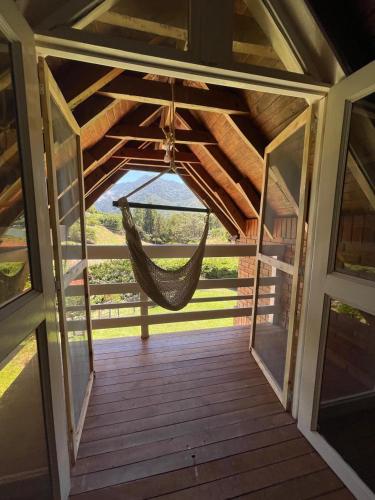 a hammock hanging from the ceiling of a porch at Hermosa Casa Campestre en el Lago Calima in Madroñal