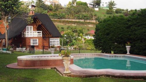 a swimming pool in front of a house at Hermosa Casa Campestre en el Lago Calima in Madroñal