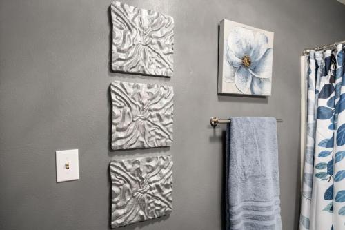 a bathroom with three towels and a flower on the wall at 2BD in Bartonville close to DT Peoria in Bartonville