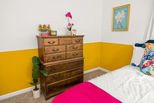 a bedroom with a dresser and a bed at Art Deco Oasis A Stylish Retreat in Peoria Heights