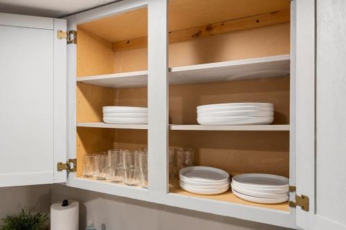 a kitchen cabinet with plates and dishes in it at Peaceful Park Living - 3BD 10mins to DT Peoria in North Pekin