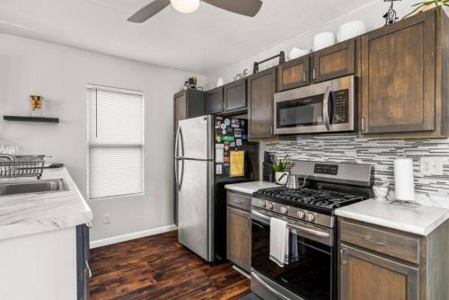 a kitchen with stainless steel appliances and wooden cabinets at Cottage on Duryea - Cozy 1BD home in the Heights in Peoria Heights