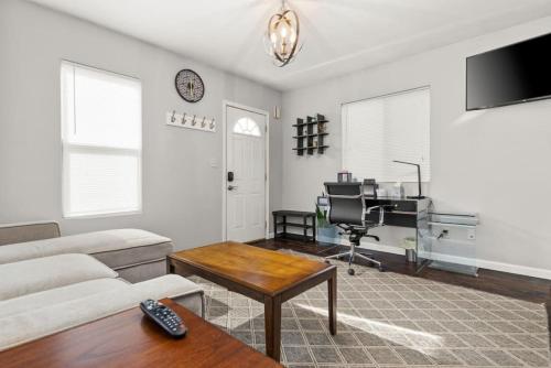 a living room with a couch and a desk at Cottage on Duryea - Cozy 1BD home in the Heights in Peoria Heights