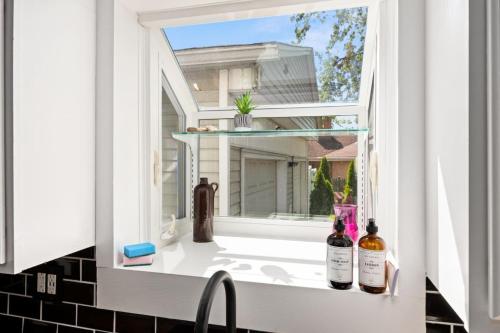 a window with three bottles of wine sitting on a sink at Suburban Sanctuary 3BD Perfect for Long Stays in Pekin