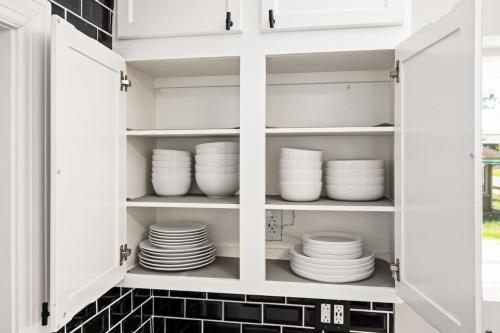 a white cabinet filled with plates and bowls at Suburban Sanctuary 3BD Perfect for Long Stays in Pekin