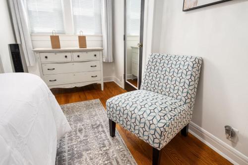 a bedroom with a bed and a chair and a dresser at Suburban Sanctuary 3BD Perfect for Long Stays in Pekin