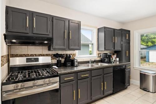 a kitchen with black cabinets and a stove at Cozy Mid Century Oasis with 2 KING beds in Peoria