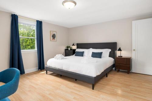 a bedroom with a large bed and a blue chair at Cozy Mid Century Oasis with 2 KING beds in Peoria