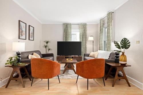 a living room with a couch and a tv at Cozy Mid Century Oasis with 2 KING beds in Peoria