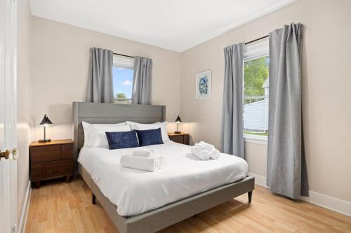 a bedroom with a large white bed with blue pillows at Cozy Mid Century Oasis with 2 KING beds in Peoria