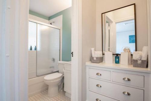 a bathroom with a toilet and a sink and a mirror at CITY VIBES - Modern Suite in the heart of Downtown in Peoria