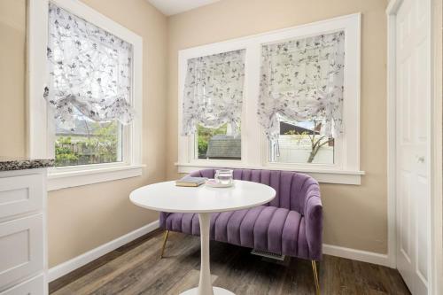 a purple couch and a table in a room with windows at Tranquil 3 Bed Retreat Sleeps 7 in Peoria