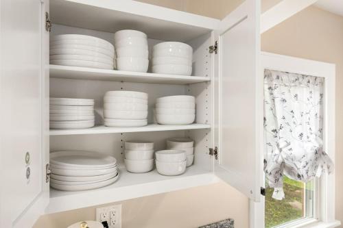 a white cabinet filled with plates and bowls at Tranquil 3 Bed Retreat Sleeps 7 in Peoria