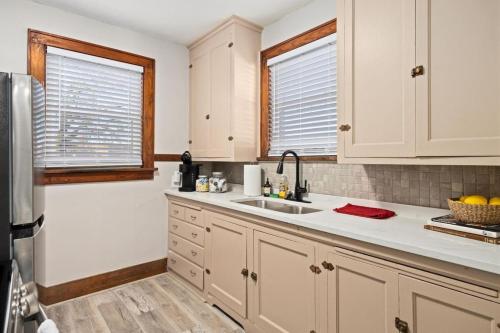 a kitchen with white cabinets and a sink at Mid-Century Bohemian Escape in Peoria Heights