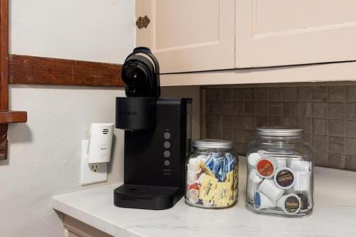 a kitchen counter with a coffee maker and two jars at Mid-Century Bohemian Escape in Peoria Heights