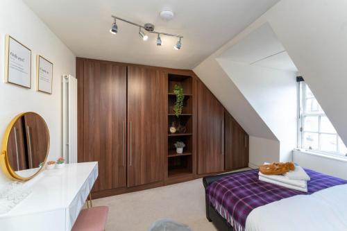 a bedroom with a bed and a sink and a mirror at Perth Penthouse at the Concert Hall in Perth