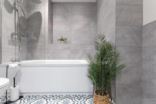 a bathroom with a white tub and a plant at Central Stirling City Escape in Stirling