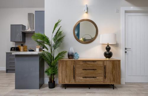 a living room with a wooden dresser and a mirror at City Centre Haven Apartment in Stirling
