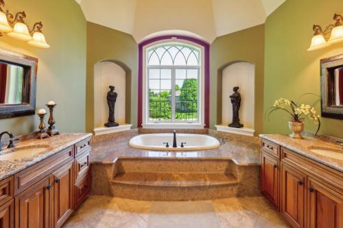 a bathroom with a tub and two sinks and a window at Grand Estate at the Preserve in Youngsdale