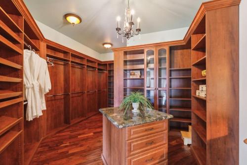 a walk in closet with wooden cabinets and a marble counter at Grand Estate at the Preserve in Youngsdale