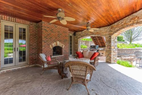 a patio with a brick wall and a ceiling fan at Grand Estate at the Preserve in Youngsdale