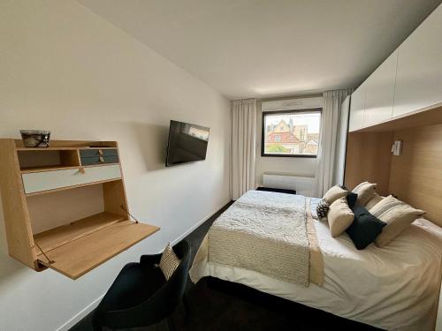 une petite chambre avec un lit et une fenêtre dans l'établissement Duplex moderne 2 chambres entre mer et commerces !, à Wimereux