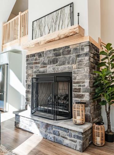 a living room with a stone fireplace at Wintervue-beautiful home at Alpine Lake in Terra Alta