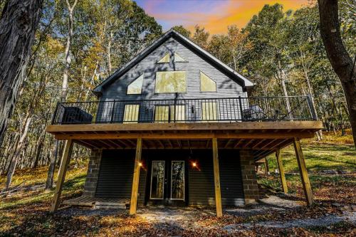 a cabin in the woods with a deck at Wintervue-beautiful home at Alpine Lake in Terra Alta