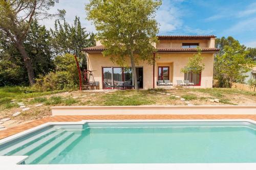 une maison avec une piscine devant une maison dans l'établissement Maison des cigales, à Langlade