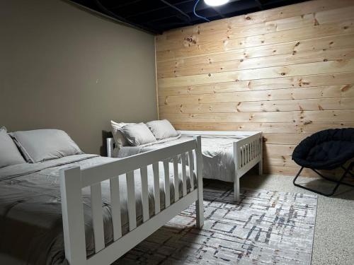 a bedroom with two beds and a wooden wall at Wintervue-beautiful home at Alpine Lake in Terra Alta
