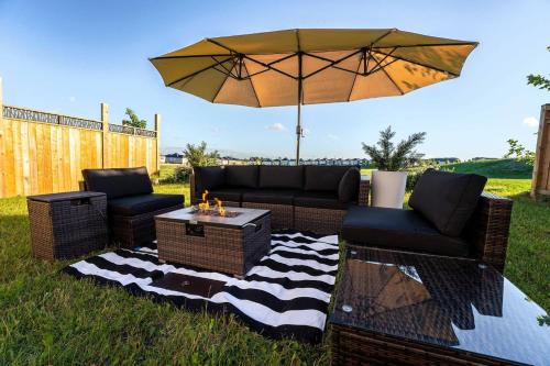 a patio with two couches and an umbrella at Spacious Family Getaway Near Nature & Dining in Cambridge