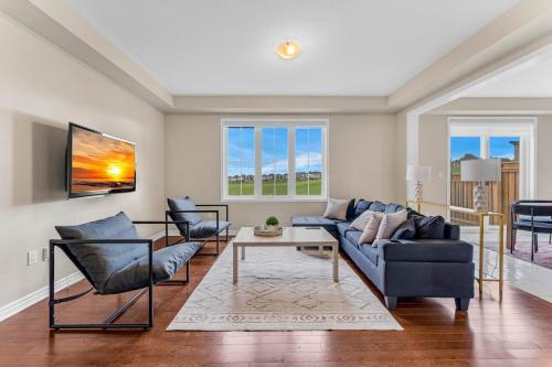 a living room with a blue couch and chairs at Spacious Family Getaway Near Nature & Dining in Cambridge