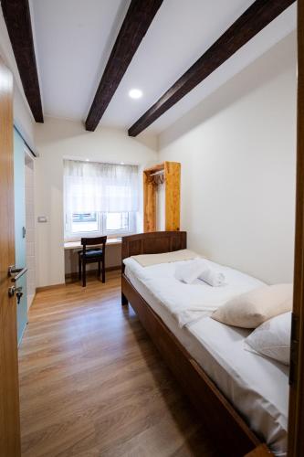 a bedroom with a large bed and a desk at 4 TeTE in Vrhpolje