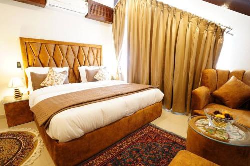 una camera da letto con un letto, un divano e una sedia di Walisons Homestay Spirea 1 BHK plus 1 Sofa Bed Apartment a Srinagar