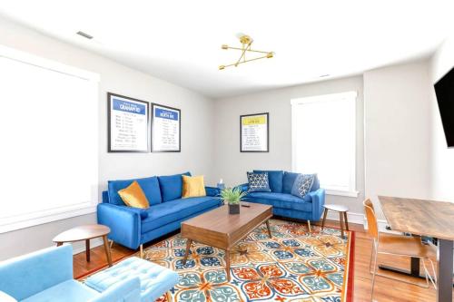 a living room with blue couches and a table at Stay, Play and Pass Go at the Monopoly Penthouse! in Richmond